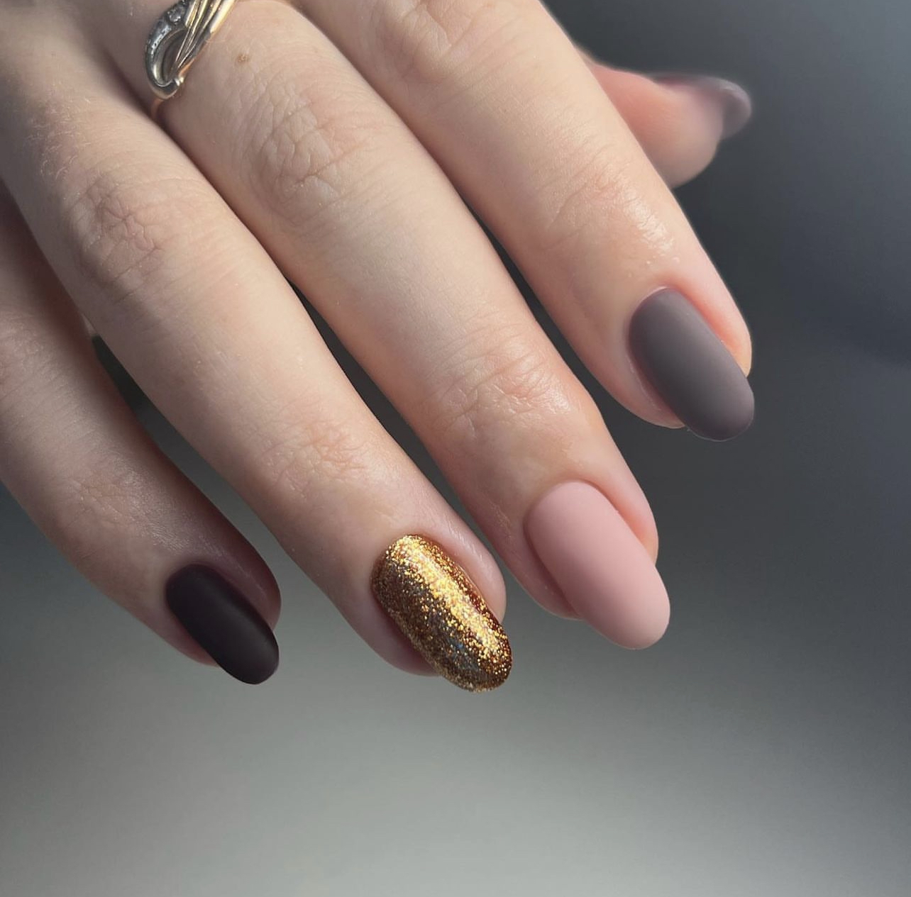 Matte nagels in taupe en chocolade, de ringvinger in goudglitter