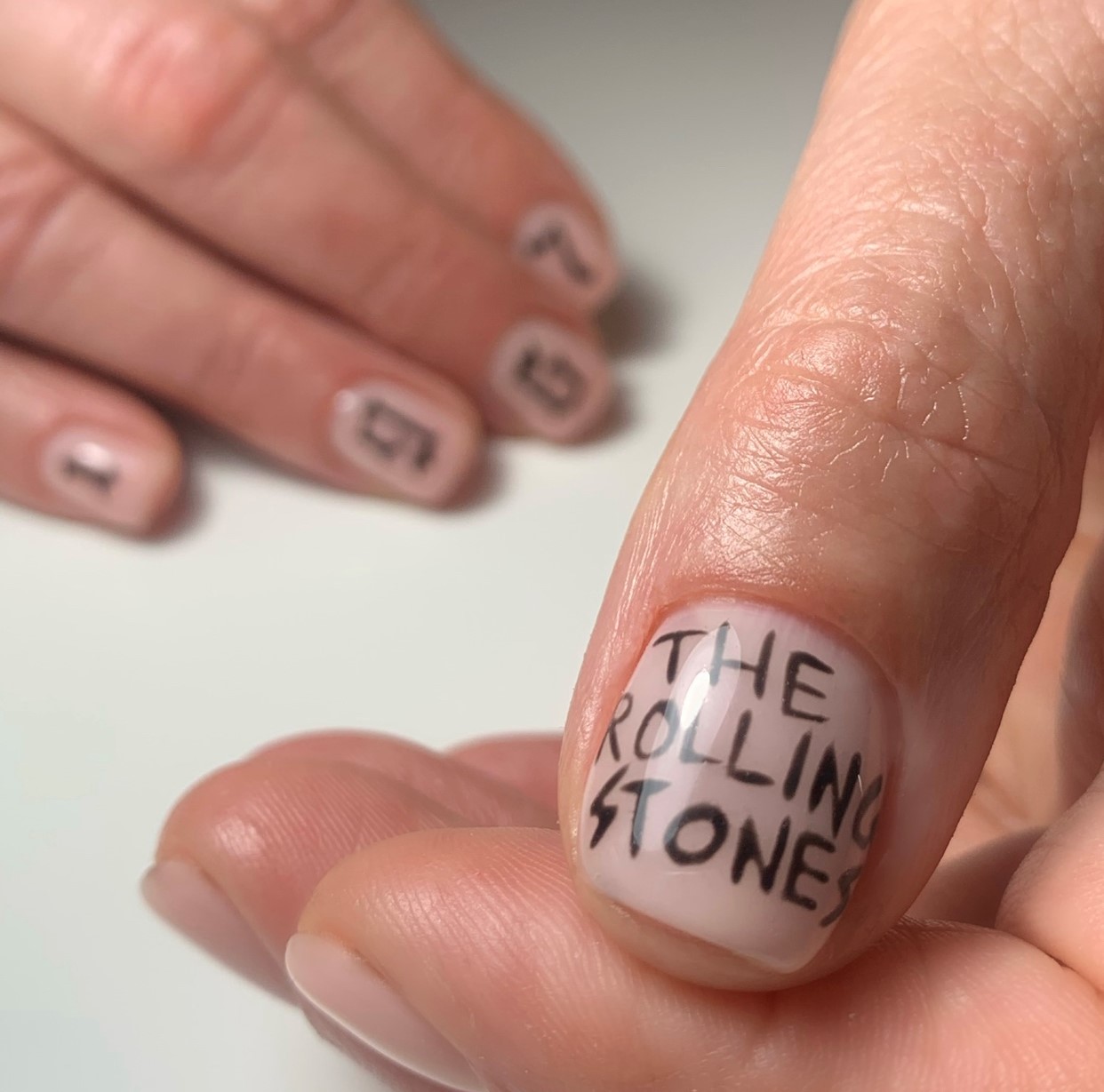 Duimnagel met de woorden The Rolling Stones met de hand geschilderd