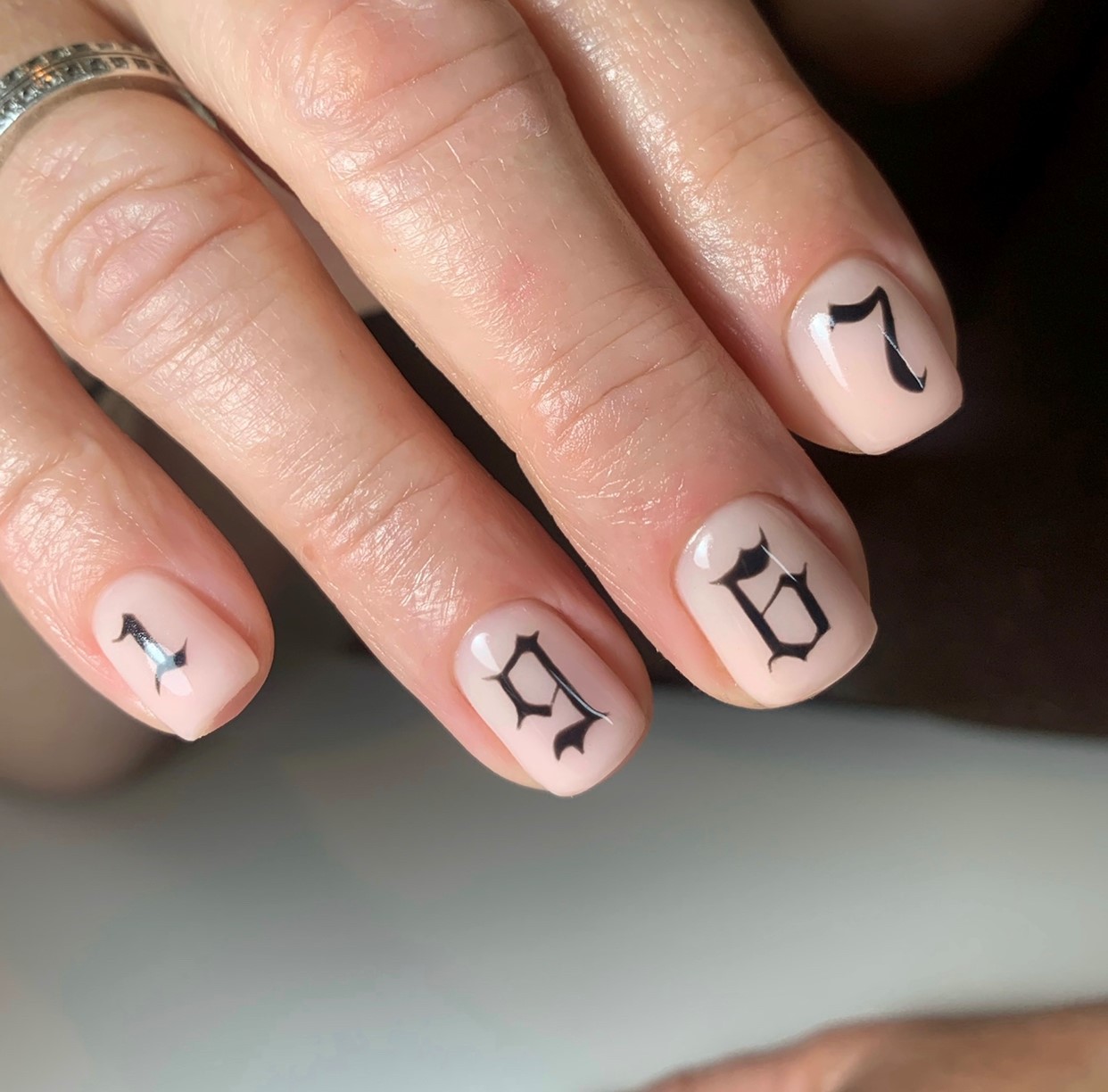 Nude nagels met de cijfers 1, 9, 6 en 7 in gotische letters met de hand geschilderd