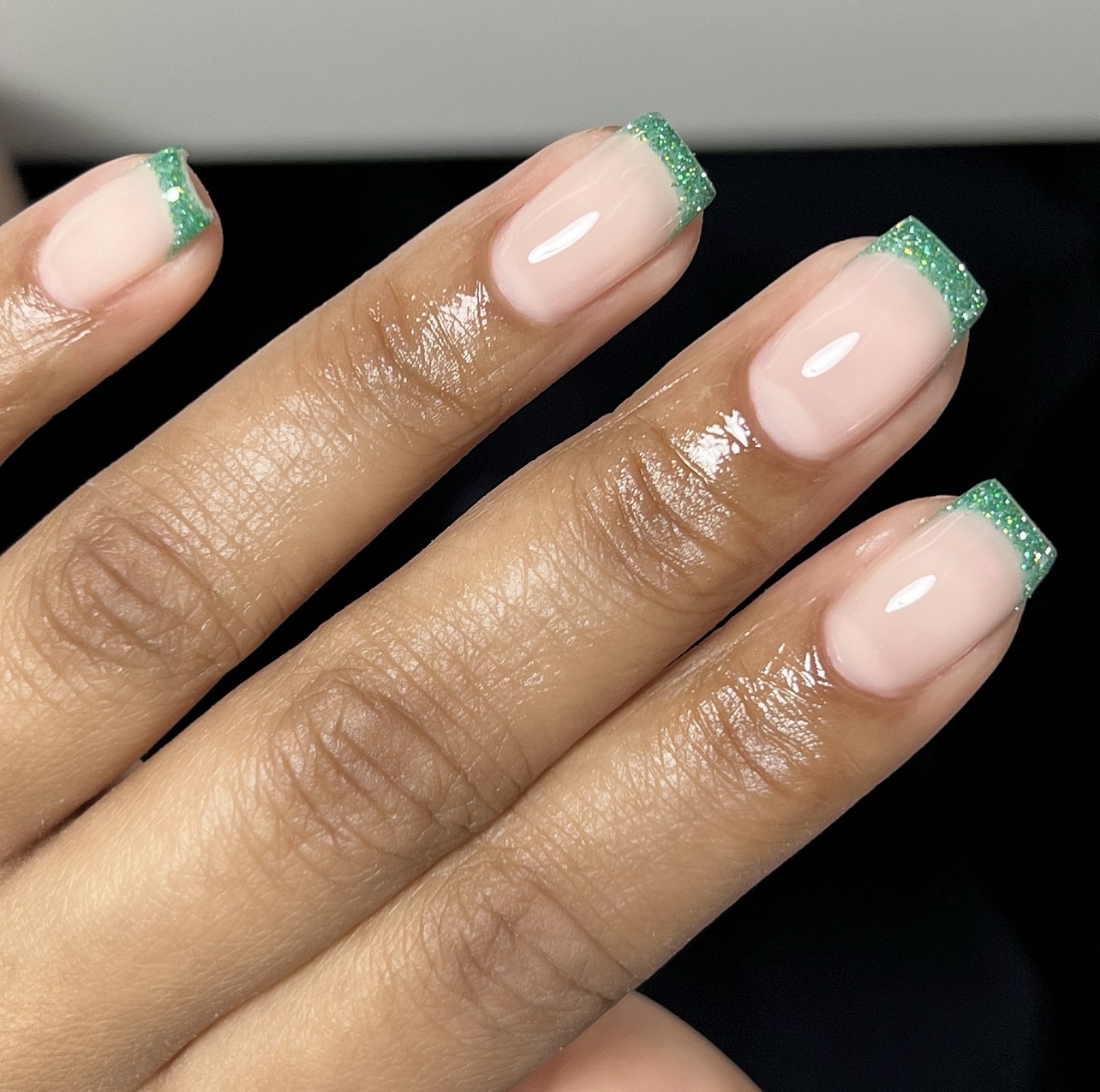 Nude French manicure met tips van groene glitter